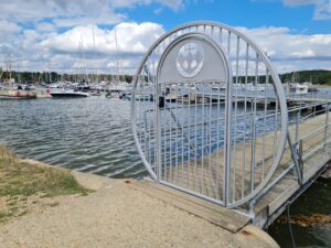 Marine inspired metal gate with mechanical keypad lock at boat yard