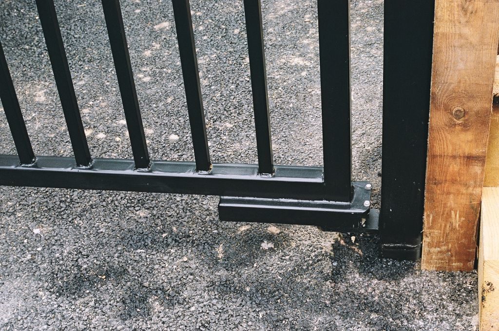 Close up of gate closing motor on black metal gate.