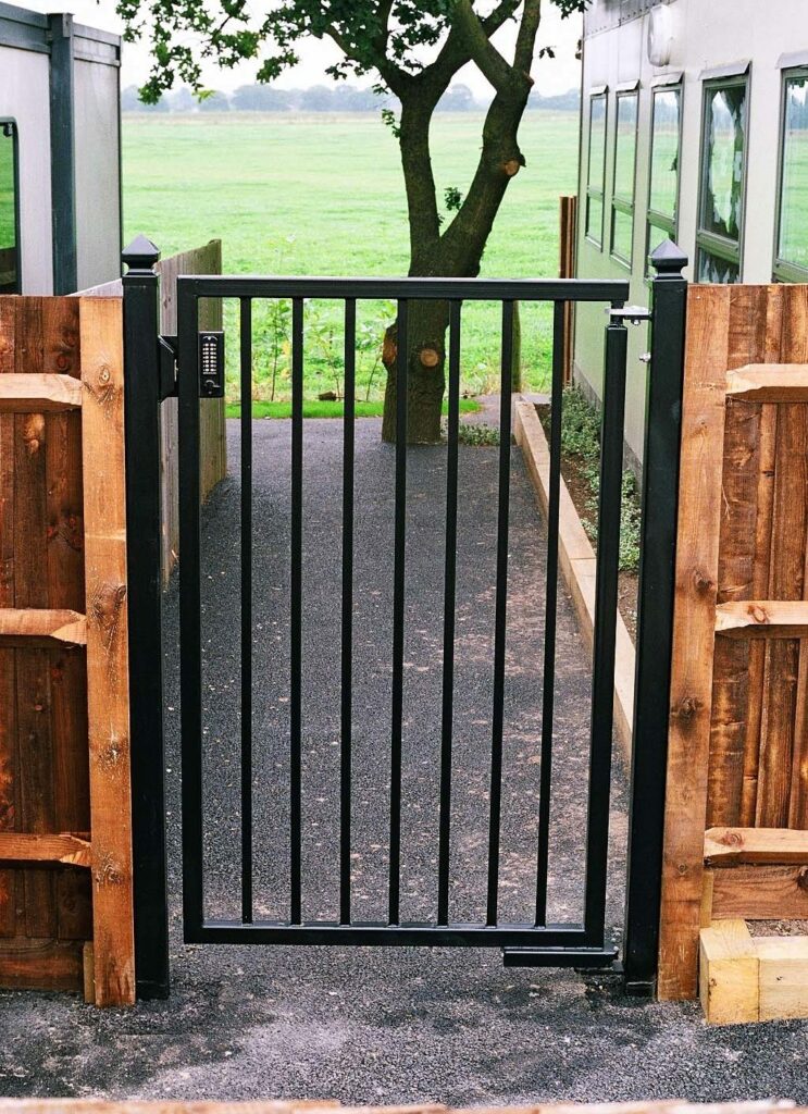 metal gate installed on wooden fence with gate closing mechanism