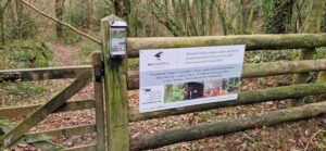 Wooden gate in woodlands with big sign for Butterwell Farm holiday cottages with keyless gate lock for wooden gate installed.