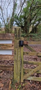 Backside of wooden gate and fencing on private estate leading onto public footpath. keypad digital lock installed on the timber gate