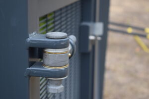 Heavy duty hinge with brass washers installed in metal mesh gate