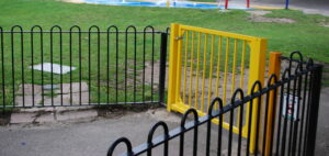 yellow gate and bow top railings in play park leisure centre or kids playground area