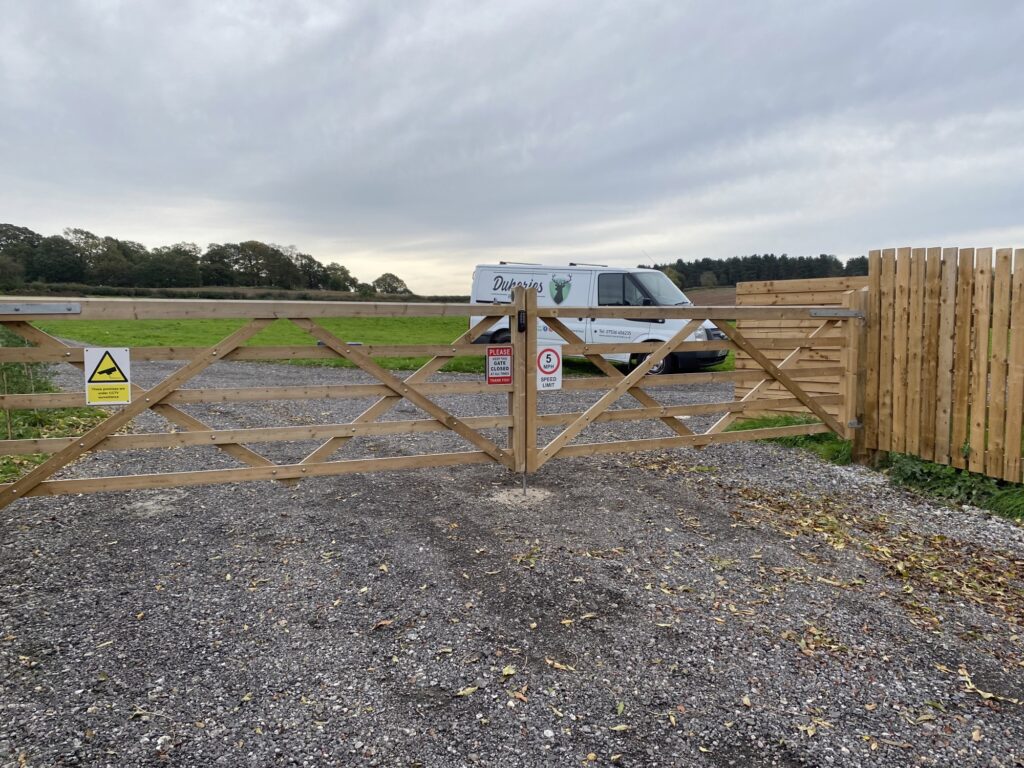 Anticorrosion lock with code and keypad on both sides installed on a wooden frame gate on campsite