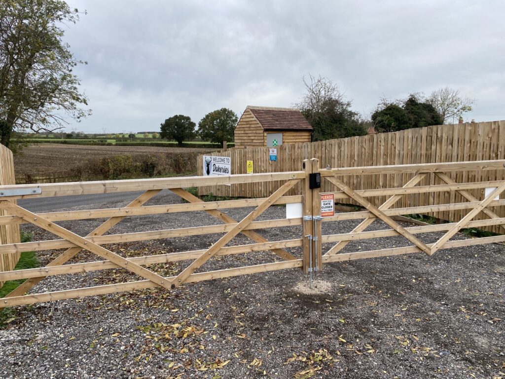 Large softwood timber entrance gate to glamping site with keyless keypad lock installed on the front