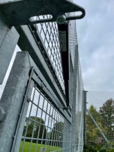 Gate hardware gate closer installed on metal gate at Cuckfield Lawn Tennis club