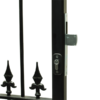 Narrow deadlocking mortice lock installed into metal gate frame. Key cylinder on front and deadbolt sticking out of frame to right