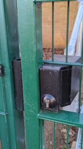 Quick exit gate lock installed on green metal gate at a hospital gate