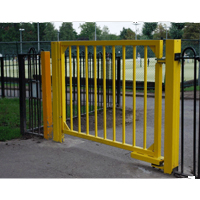 Public pedestrian gate in yellow coloured metal. In front of a tennis court