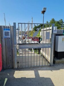 marina gate with automatically closing gate closer installed at boat dock yard